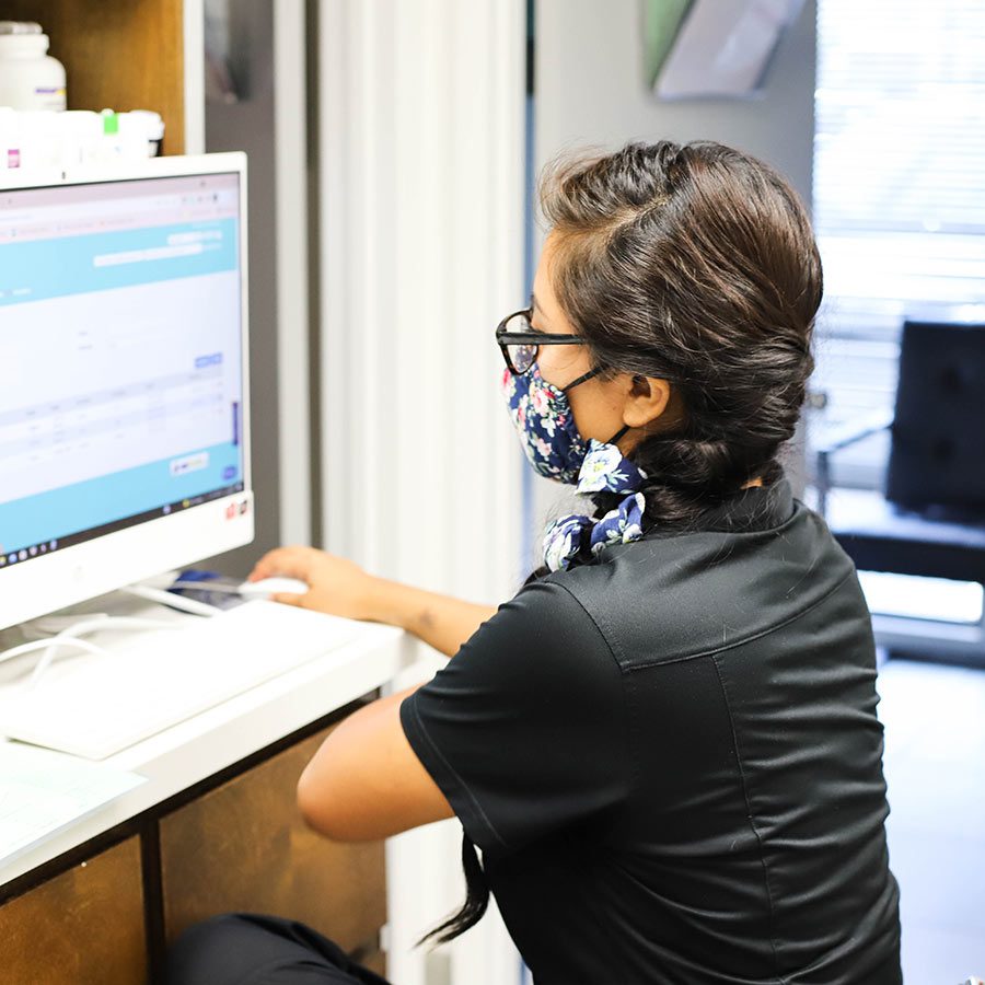 JPV-2021--Tech-in-PIMS-2 veterinary team member using computer