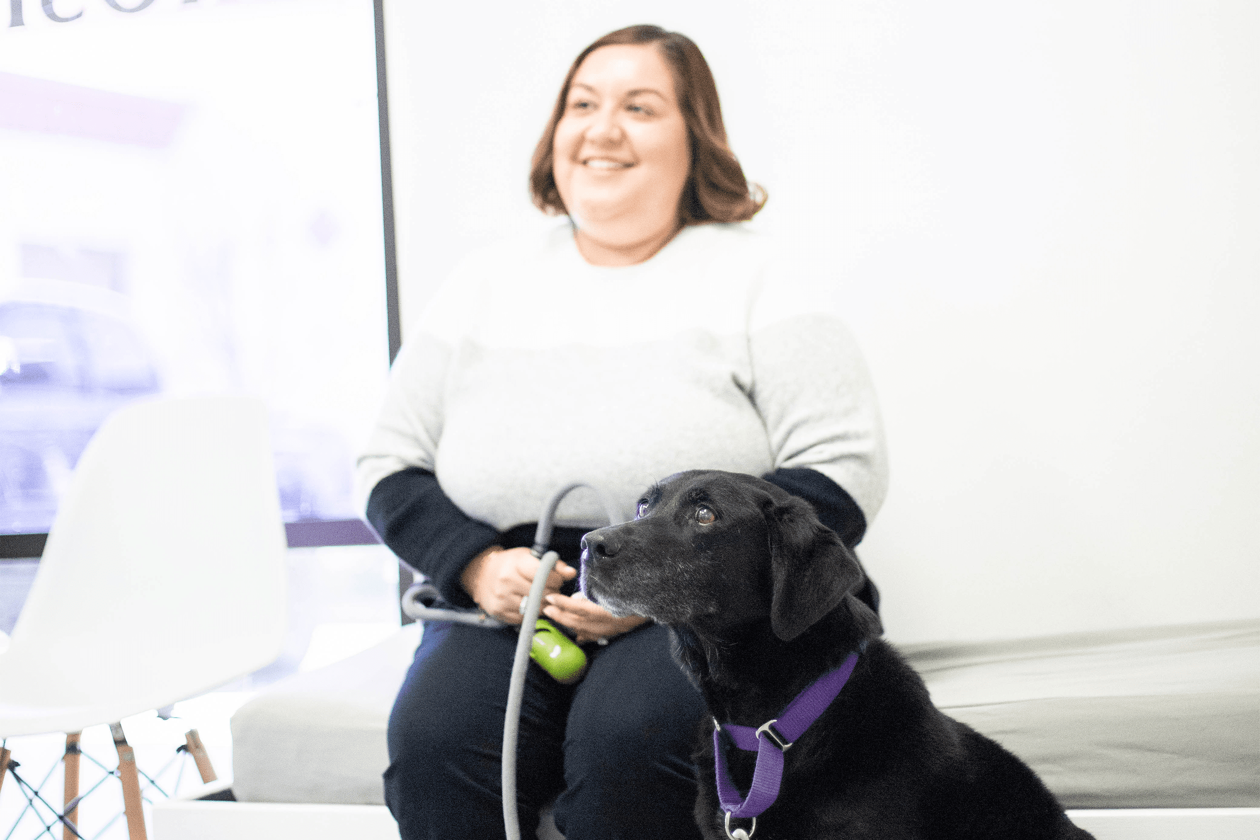 Pet parent happily sitting in the lobby with their dog Pet parent happily sitting in the lobby with their dog