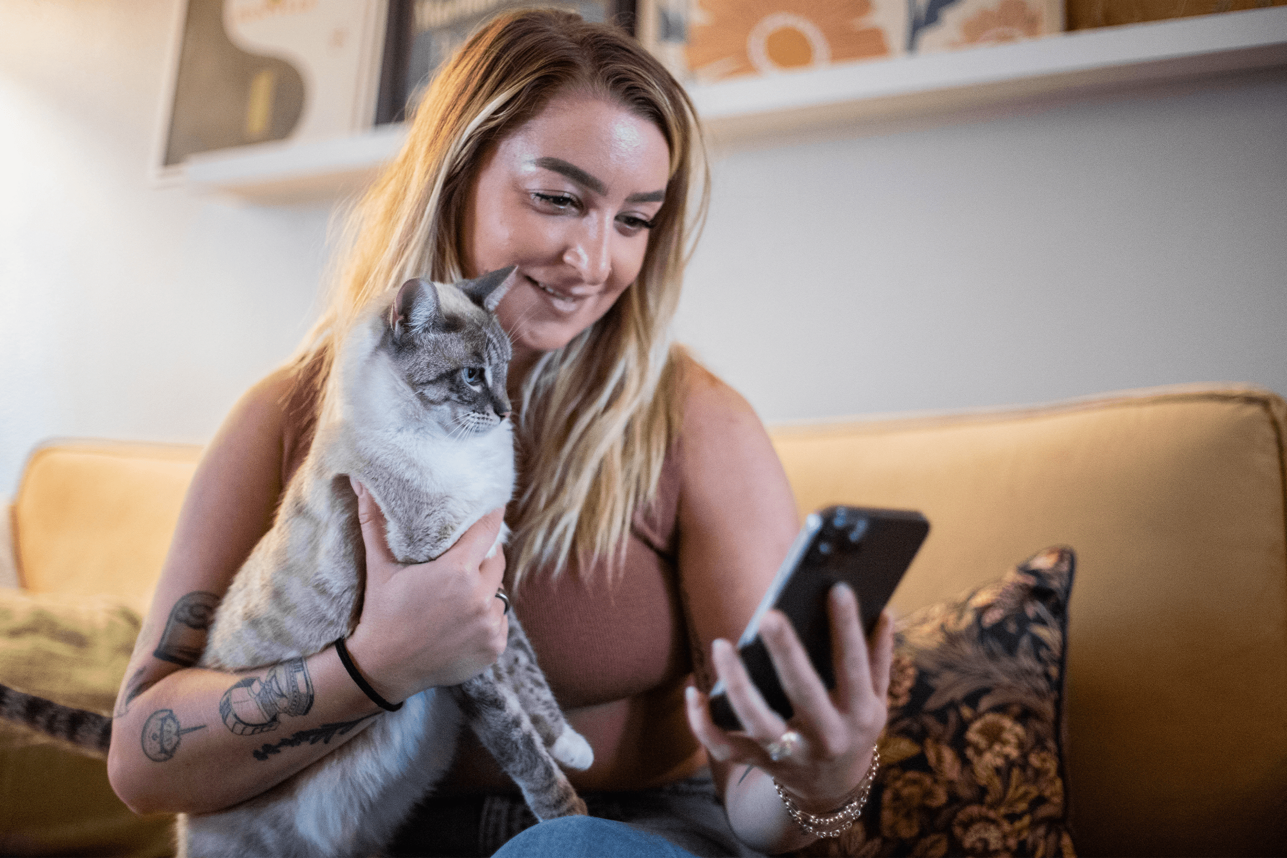 Pet parents holding their cat while using their phone Pet parents holding their cat while using their phone