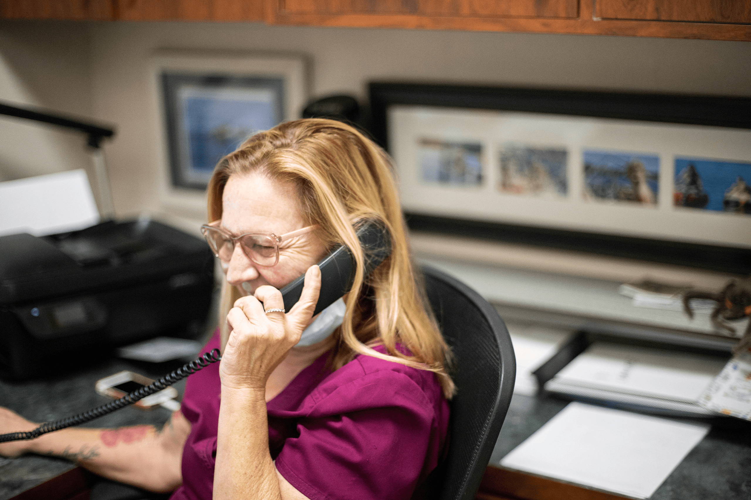 Veterinary PM happily chatting on the phone at in their office Veterinary PM happily chatting on the phone in their office